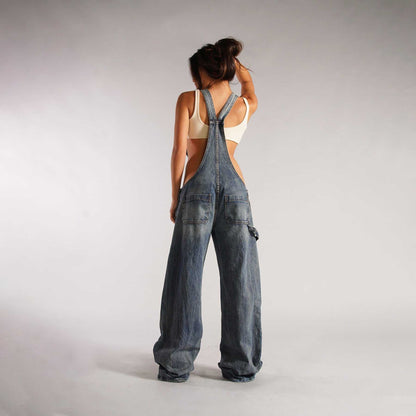Back view of a woman wearing wide leg zipper denim overalls with pockets and high waist design