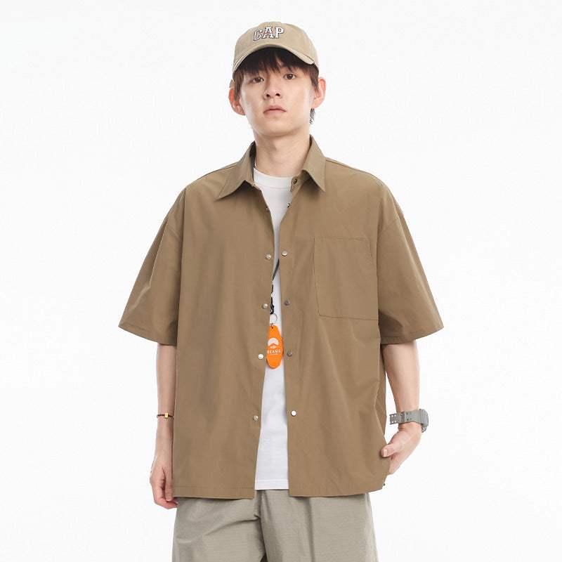 Teen male wearing khaki loose casual overshirt for leisure, paired with a cap and watch.
